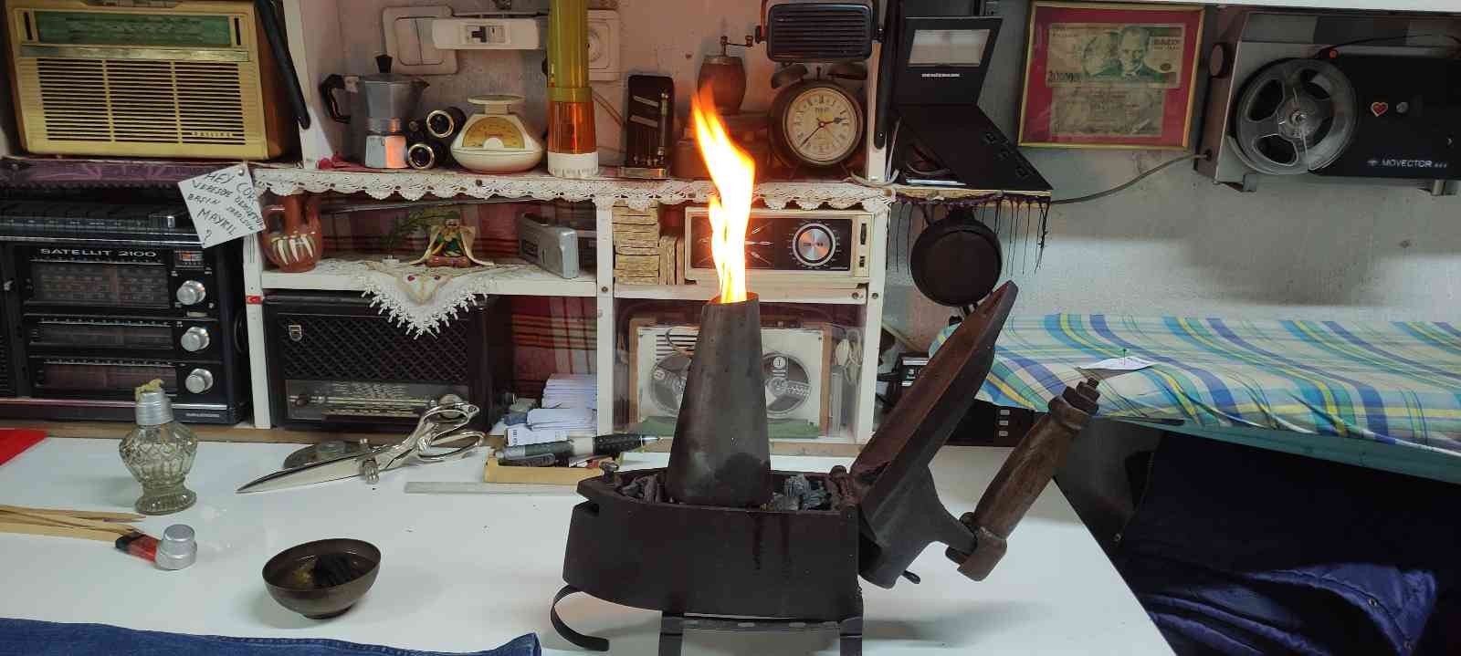 Terzi kömürlü ütüyle kumaşları ütülüyor